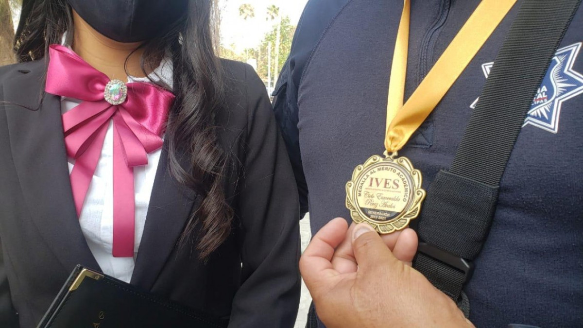 Sorprende a su padre con título y medalla de excelencia 