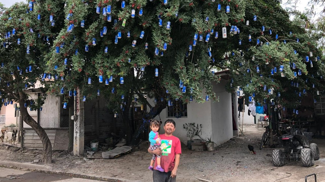 Mecánico decora árbol navideño con latas de cerveza
