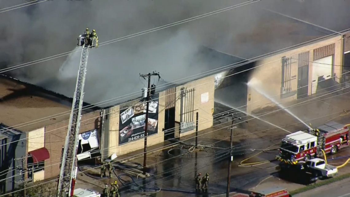 Bomberos trabajan en incendio de almacén