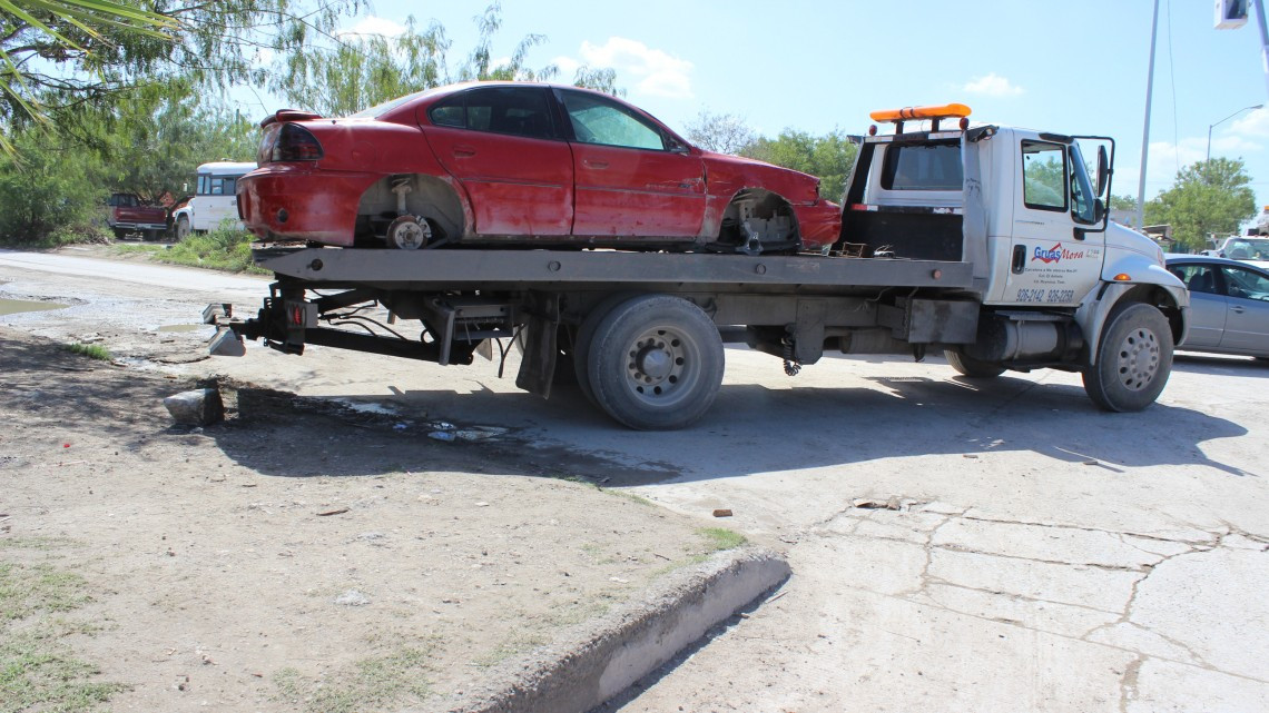 Retiran vehículos desmantelados por invadir vía pública