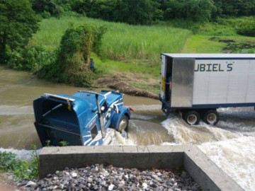 Tráiler es arrastrados por corriente de un río 